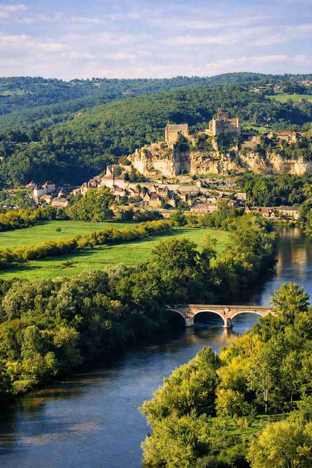 lago de dordoña rodeado de naturaleza y un castillo